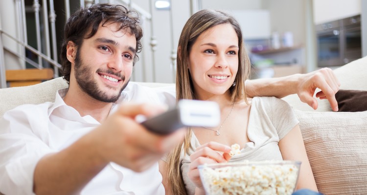 Mann und Frau mit Popcorn und Fernbedienung