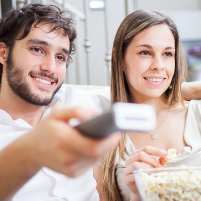 Mann und Frau mit Popcorn und Fernbedienung