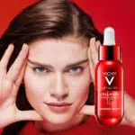 Vichy-Produkt in roter Flasche; Frau mit Händen am Gesicht