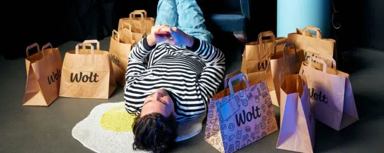 Mensch wird von Wolt Tüten umringt